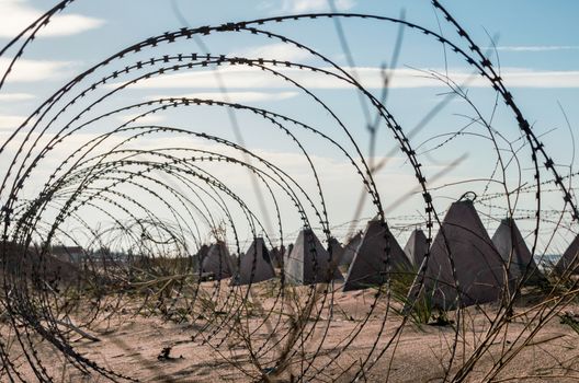 barbed wire and concrete military fence on the beach near the sea in Crimea Ukraine