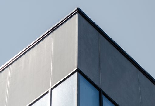 corner of a concrete building with windows