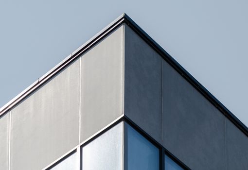 corner of a concrete building with windows