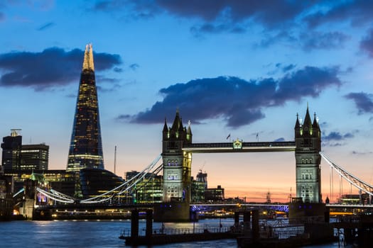 Tower Bridge, the Shard, city hall and business district in the background at night, London, Uk.