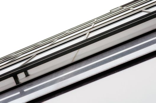 fragment of the wall and windows of a modern tall office building without people  abstract architectural monochromatic background