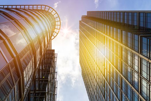 Bottom view of modern skyscrapers in business district against blue sky