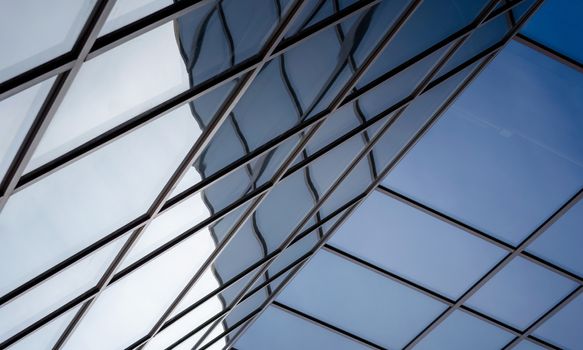 reflection with distortion in the window of a modern building color blue abstract urban background