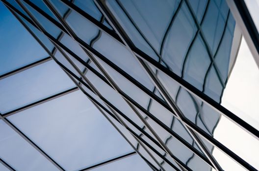 reflection with distortion in the window of a modern building color blue abstract urban background