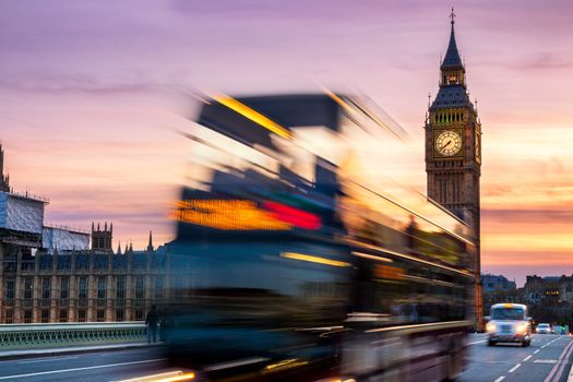 London night scene of Westminster and Big Ben with famous London bus driving by