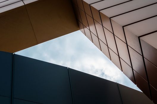 blue sky with clouds between the walls of a modern office building abstract architectural background