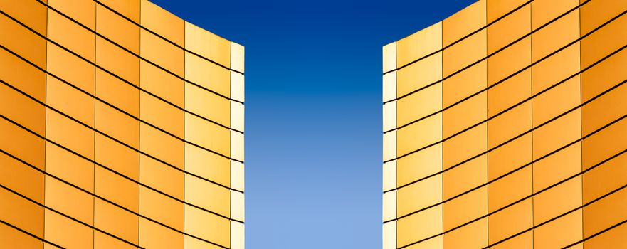 architectural abstract pattern fragment of a wall of a yellow modern building on a blue background