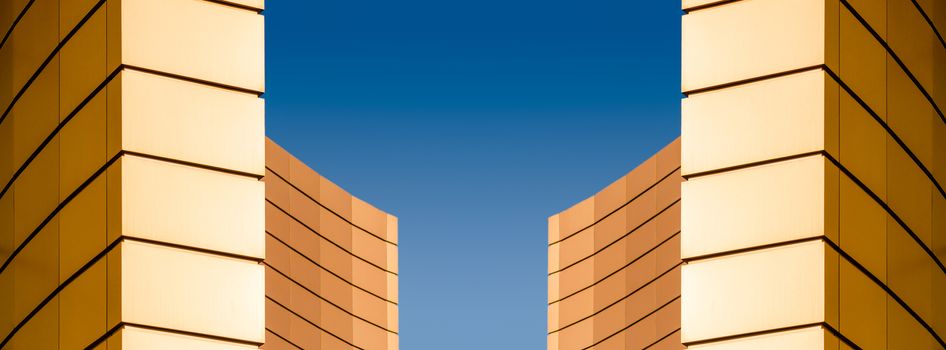 architectural abstract pattern fragment of a wall of a yellow modern building on a blue background