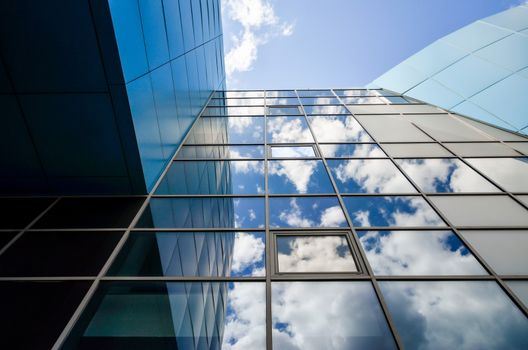 reflection of blue sky with clouds in an modern office building window