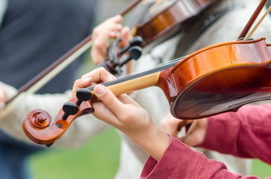 hands of a street musician girl with violin closeup