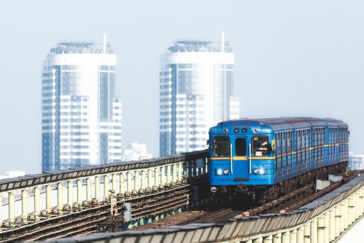 blue vintage metro cars on the background of office skyscrapers in Kiev Ukraine in the morning