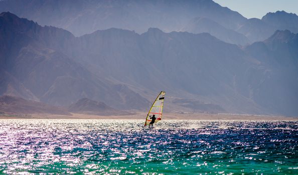 surfer ride in the sea on the background of the rocky coast in Egypt