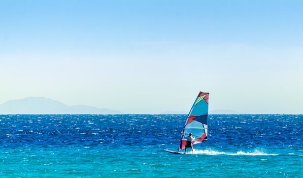windsurfer on the background of high mountains rides on the waves of the Red Sea in Egypt Dahab South Sinai