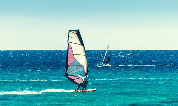 young surfer girl rides a sail in the Red Sea in Egypt Dahab