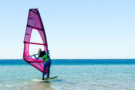 young girl windsurfer beginner learns to ride in the sea in Egypt Dahab