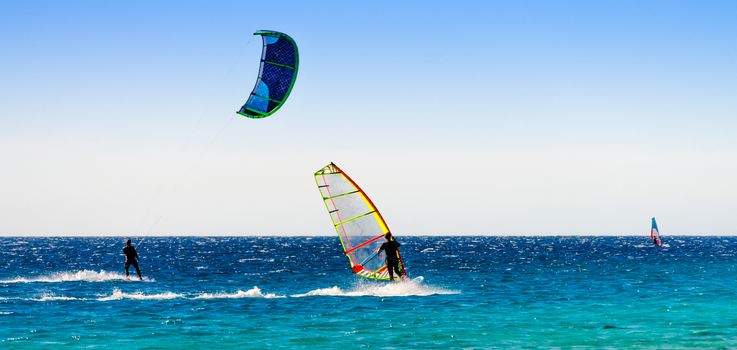 windsurfers and kitesurfers ride in the Red Sea in Egypt Dahab