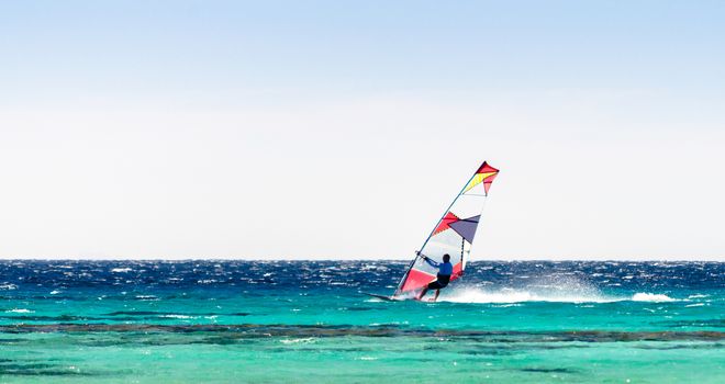 surfer rides in the Red Sea on the background of a clear sky in Egypt. Dahab