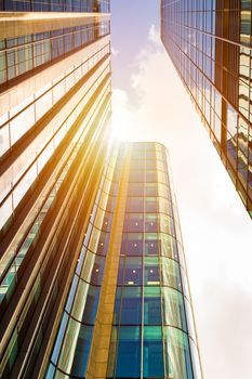 Modern glass exterior of corporate office buildings shot from a low angle.
