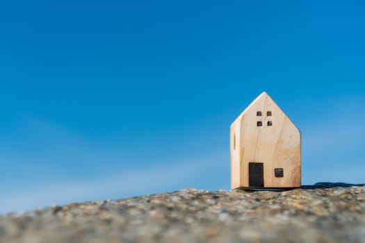 Model of a little house on sand with nature beach background. Dream life concept.