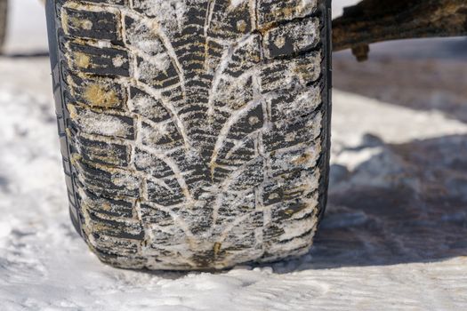 Tire for winter with spikes and its imprint on the road covered with snow