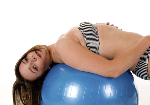 A pretty brunette woman leaning over a blue exercise ball