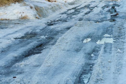 road covered with snow and ice with ruts on the street of the provincial Russian city