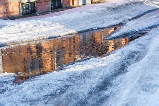 road covered with snow and ice with ruts on the street of the provincial Russian city