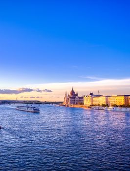 The Hungarian Parliament Building located on the Danube River in Budapest Hungary at sunset.