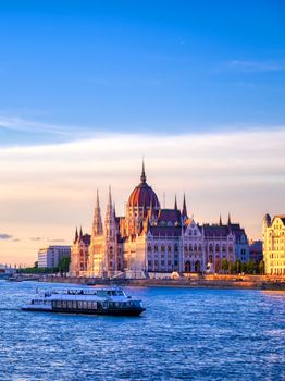 The Hungarian Parliament Building located on the Danube River in Budapest Hungary at sunset.