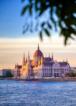 The Hungarian Parliament Building located on the Danube River in Budapest Hungary at sunset.