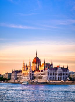 The Hungarian Parliament Building located on the Danube River in Budapest Hungary at sunset.