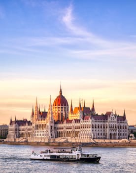 The Hungarian Parliament Building located on the Danube River in Budapest Hungary at sunset.