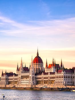 The Hungarian Parliament Building located on the Danube River in Budapest Hungary at sunset.