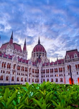 The Hungarian Parliament Building located on the Danube River in Budapest Hungary at sunset.