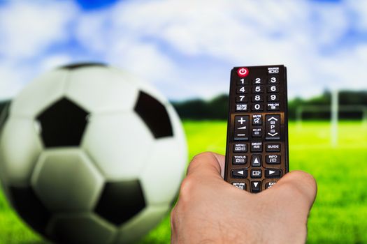 Watching soccer / football game on modern tv, with a close-up of the remote control
