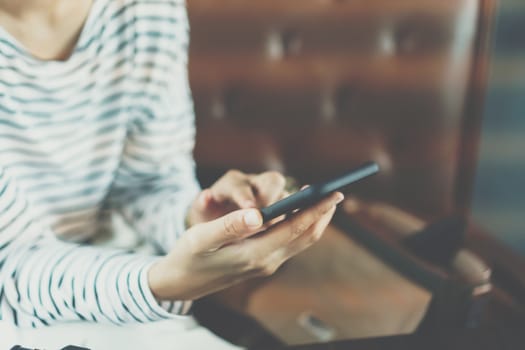 Woman hand using smartphone to do work business, social network, communication in public outdoor.