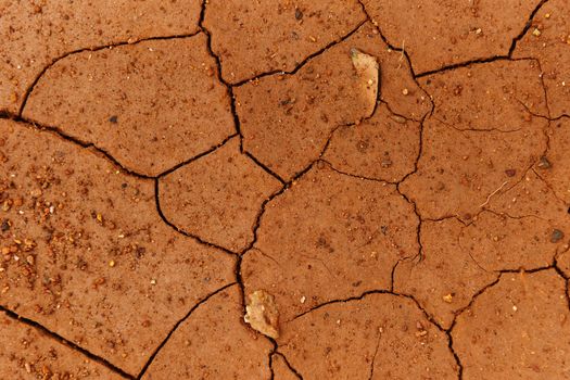 Cracks of the dried soil in arid season / Arid soil , Cracked earth texture of ground broken and rough surface red mud clay top view 