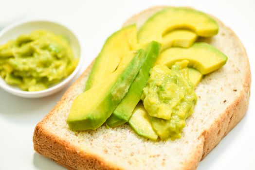 Avocado sliced and avocado toast on white plate background fruits healthy food concept / avocado dip mashed