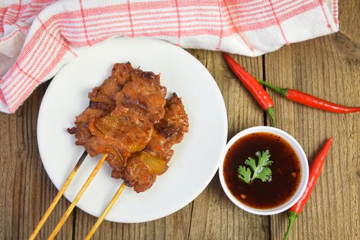 Grilled pork skewer with sauce on white plate / Pork satay Thai and Indonesian food menu Asian , top view