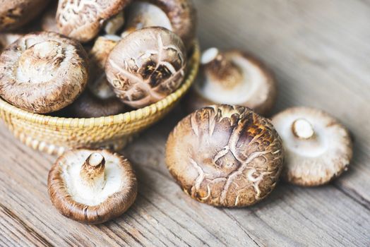 Fresh mushrooms on basket and wooden table background / Shiitake mushrooms