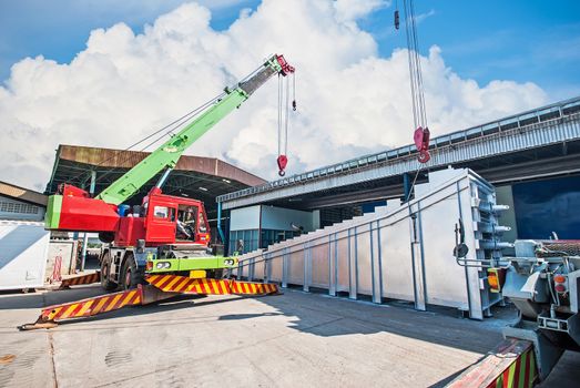 Mobile crane operating by lifting and moving an heavy electric generator