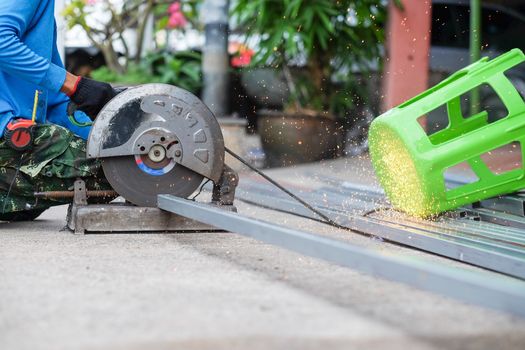 The man working on cutting a metal and steel with compound mitre saw