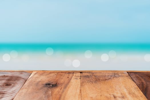 Selective focus of old wood table with beach in summer and  blue sky background for display your product.