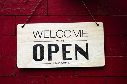 A business sign that says open on cafe or restaurant hang on door at entrance. Vintage color tone style.