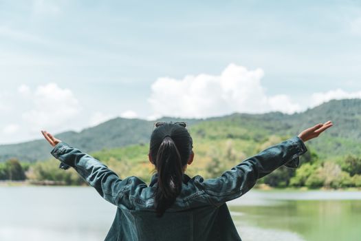 Woman rise hands up to sky freedom concept with blue sky and summer nature landscape of mountain background.