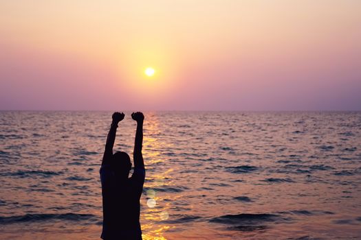 Man rise hands up to sky freedom concept with sunset sky and summer beach background.