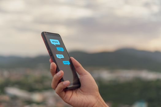 Women hand using smartphone typing, chatting conversation in chat box and icons social media app pop up. maketing technology background concept.