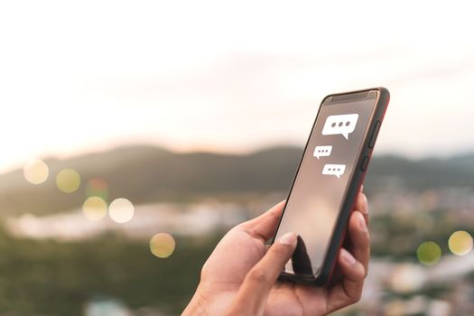 Women hand using smartphone typing, chatting conversation in chat box and icons social media app pop up. maketing technology background concept.