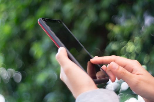 People hand using smartphone with blur cafe shop background. Business, financial, trade stock maket and social network concept.