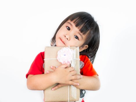 Happy Asian little child girl hugging a gift box wrapped in recycled paper isolated on white background.